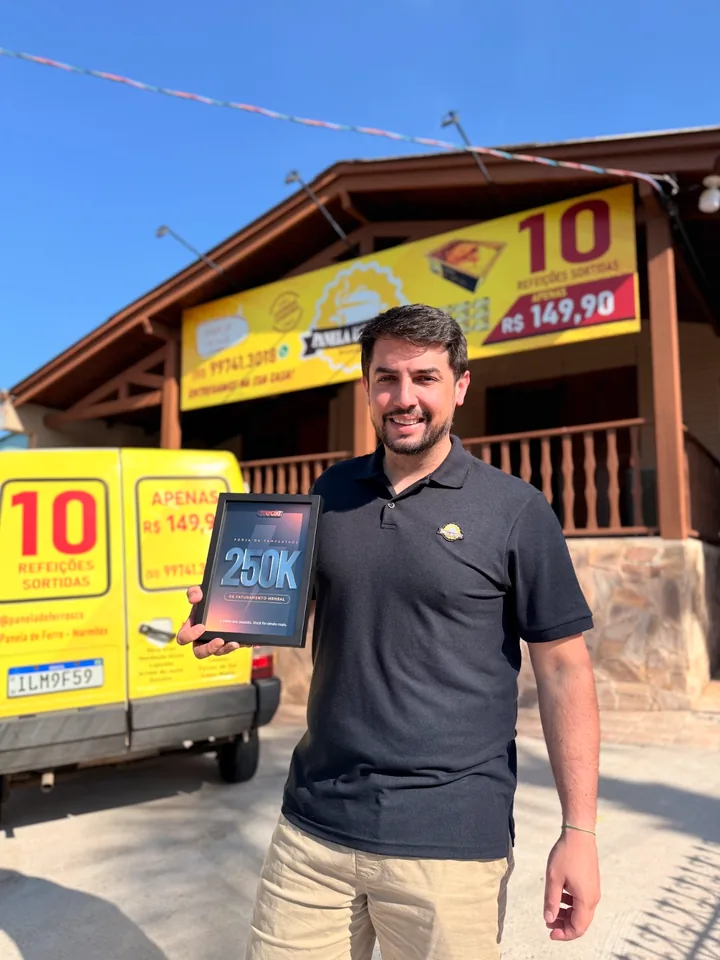 Rodiego Wink, da Panela de Ferro, com a placa de R$ 250 mil da Breakr em frente ao restaurante